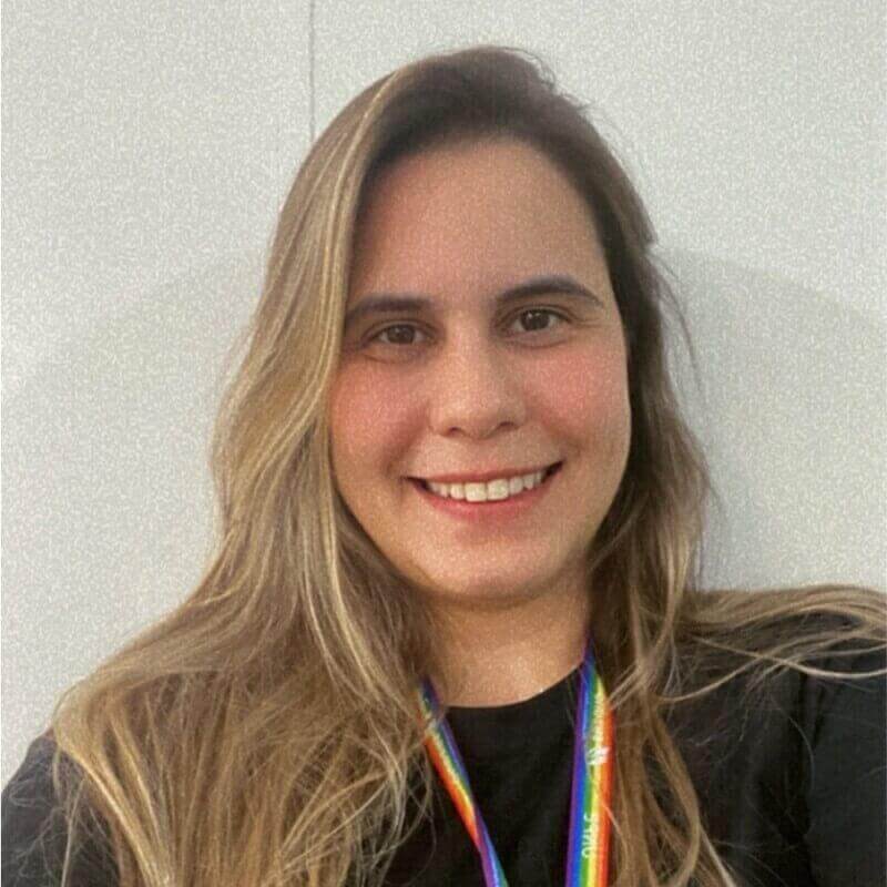 Mulher branca de cabelo loiro liso e olhos castanhos sorrindo.